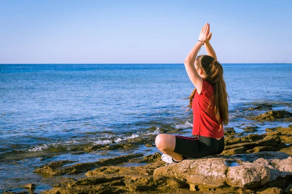 瑜伽姿势在海边沉思的年轻女孩 — 图库照片