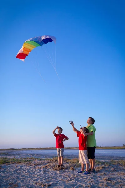 Enfants lançant le cerf-volant arc-en-ciel ensemble — Photo