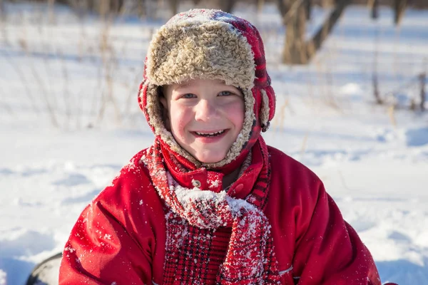 Rozkošný usměvavý chlapec v pozadí sníh — Stock fotografie