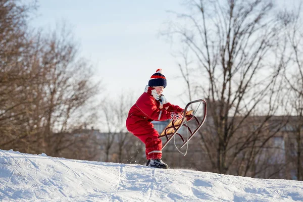 乗馬を待っている雪に覆われた丘の上にそりの少年 — ストック写真
