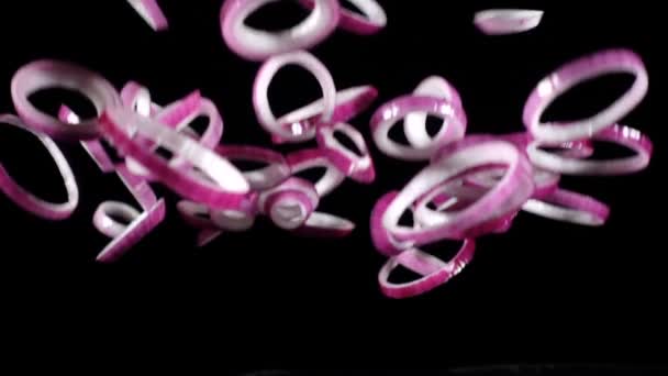Падающие кольца ломтиков красного лука, замедленная съемка — стоковое видео