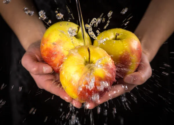 Lavarse las manzanas rojas amarillas en las manos de las mujeres —  Fotos de Stock