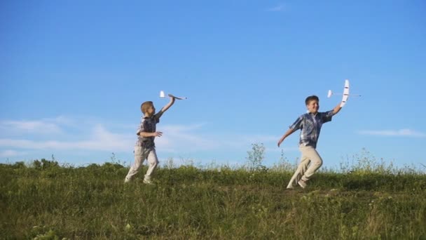 Zwei Jungen Laufen Mit Seinen Selbstgebastelten Flugzeugen Über Das Feld — Stockvideo