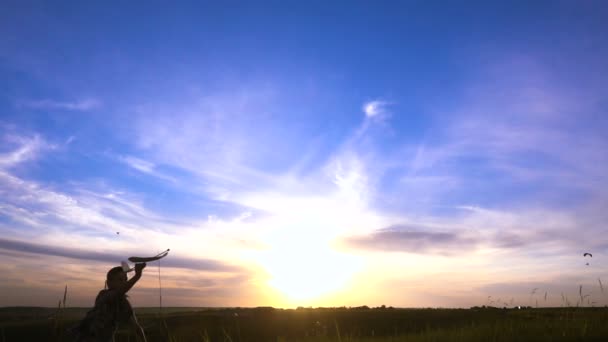 Silhouet van jongen met vliegtuig tegen zonsondergang — Stockvideo