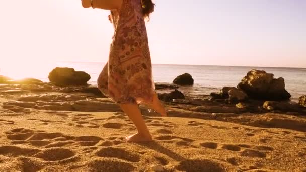 太陽が降り注ぐビーチで裸足を実行している若い女の子 — ストック動画