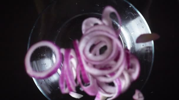 Caída de los cortes de cebolla roja en un tazón de vidrio, cámara lenta — Vídeo de stock