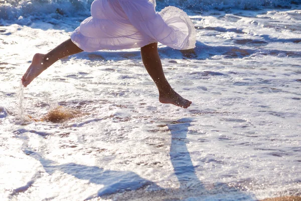 Jambes de jeune femme qui court sur le surf — Photo