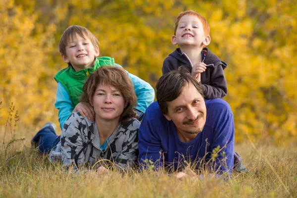 2人の子供が秋の風景の上に横たわっている家族 — ストック写真
