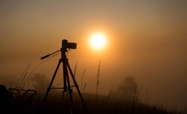 Silhouette einer Fotokamera bei Sonnenaufgang im Nebel — Stockfoto