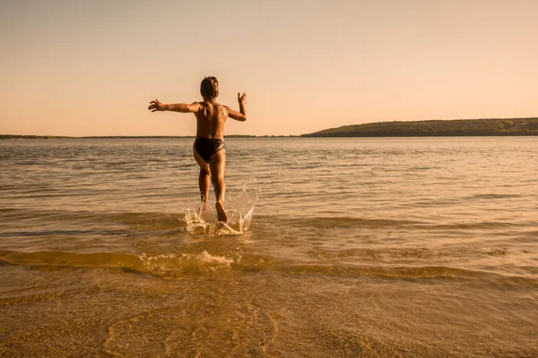 水しぶきと水の上を走っている少年 — ストック写真