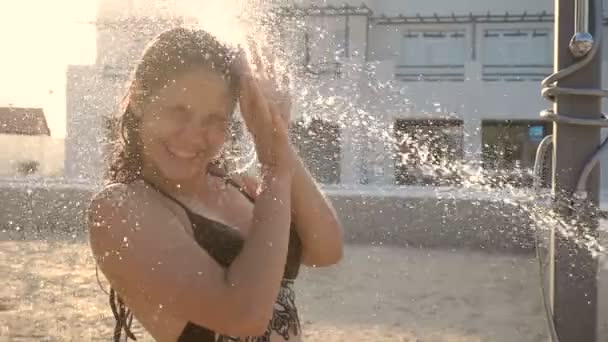 Chica se vierte chorro de agua de una ducha — Vídeos de Stock