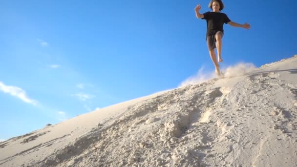 Garçon Actif Sautant Colline Sable Avec Des Vagues Poussière Ralenti — Video