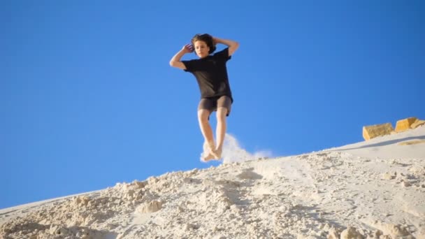 Actieve Jongen Springen Met Salto Van Zandheuvel Met Stofgolven Slow — Stockvideo