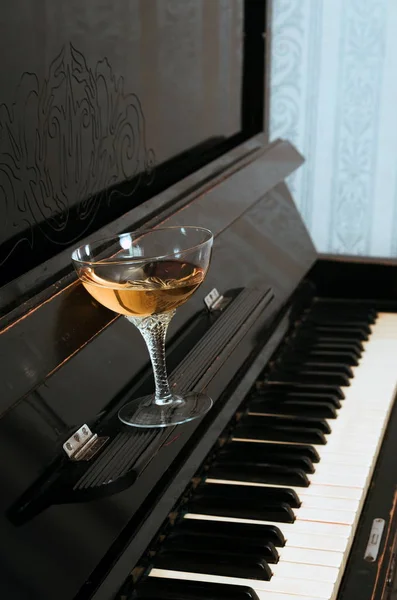 钢琴上的玻璃酒精饮料 — 图库照片