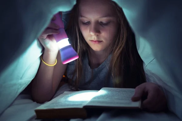 若い女の子がベッドで本を読んで — ストック写真