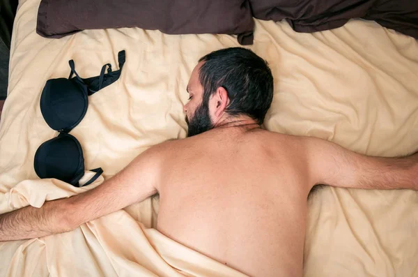 Чоловік Спить Ліжку Біля Жіночого Бюстгальтера — стокове фото