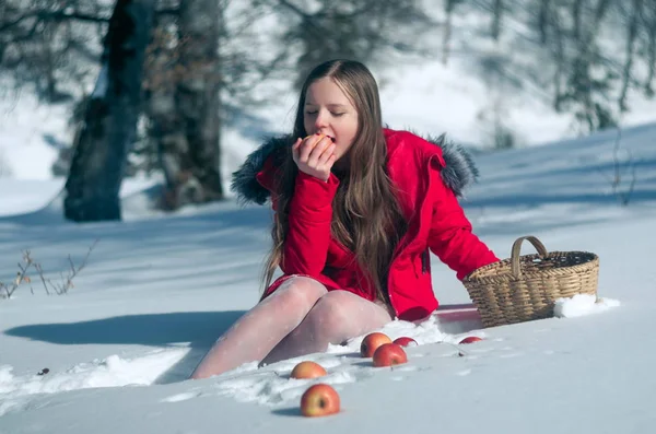 Flicka i snön med äpplen — Stockfoto