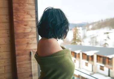Kışın balkonda esmer bir kadın.