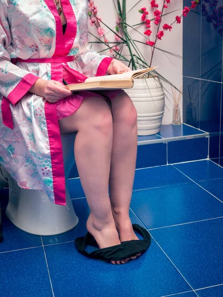 トイレに本と一緒に座っている女 — ストック写真