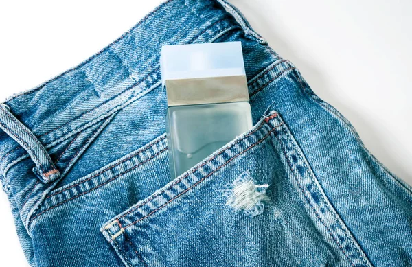 Fles parfum op de jeans — Stockfoto