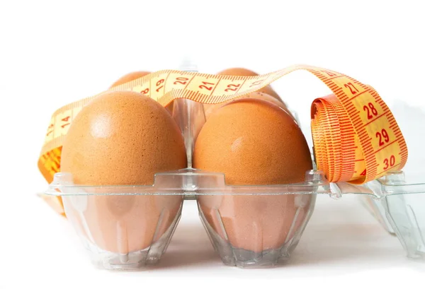 Яйца с диетическим счетчиком на белом — стоковое фото