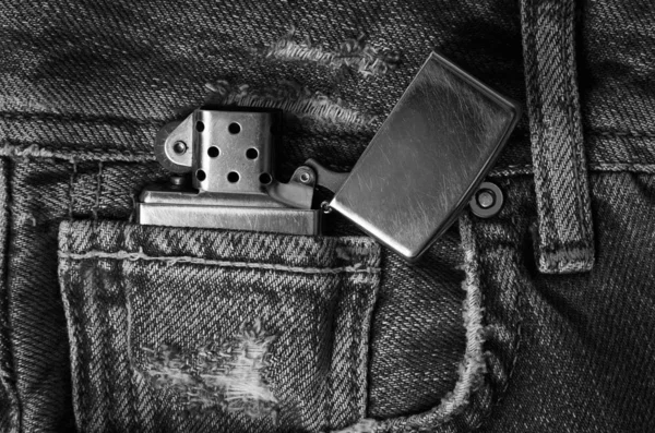 Металлическая зажигалка на джинсах — стоковое фото