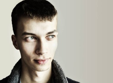 portre 90 derece döndürülmüş: karanlık arka planda genç bir adamın yüzü