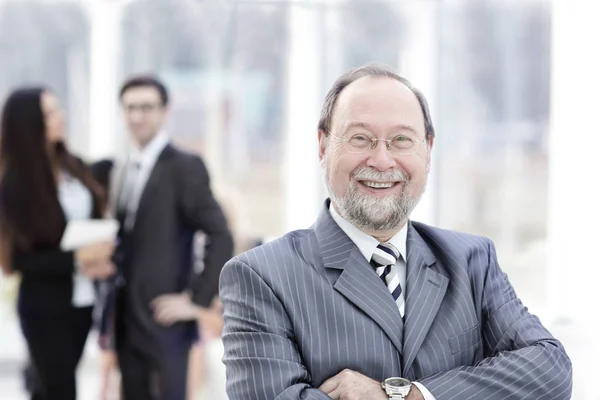 Business man at the office with a group behind him — Stock Photo, Image