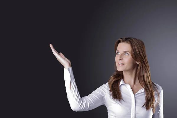 Business woman pointing on copy space.isolated on dark — Stock Photo, Image
