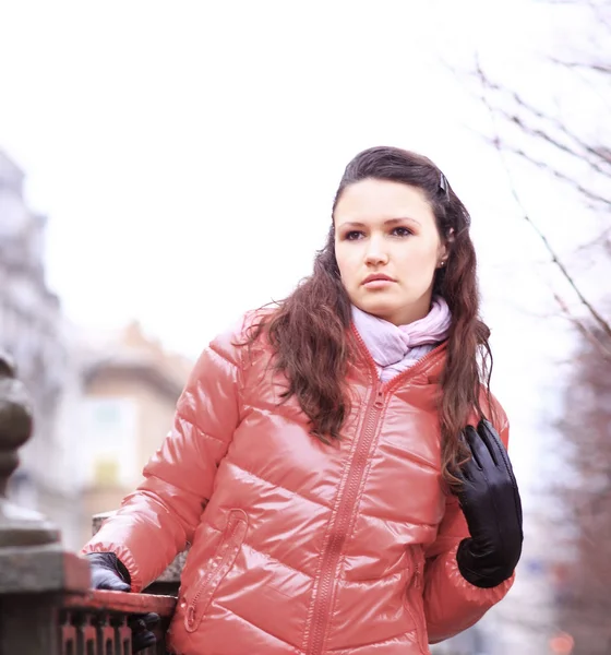 Young woman in red autumn jacket on a background of city — Stock Photo, Image