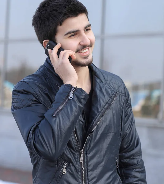 Jonge man praten op een mobiele telefoon op straat — Stockfoto