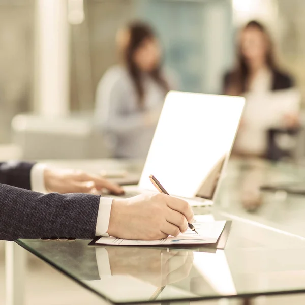 Hombre de negocios exitoso que trabaja en el ordenador portátil con datos financieros en el lugar de trabajo en una oficina moderna. — Foto de Stock