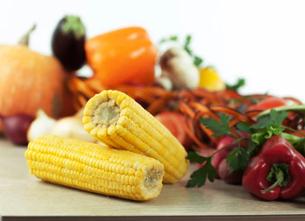 Corn on the background of fresh vegetables — Stock Photo, Image