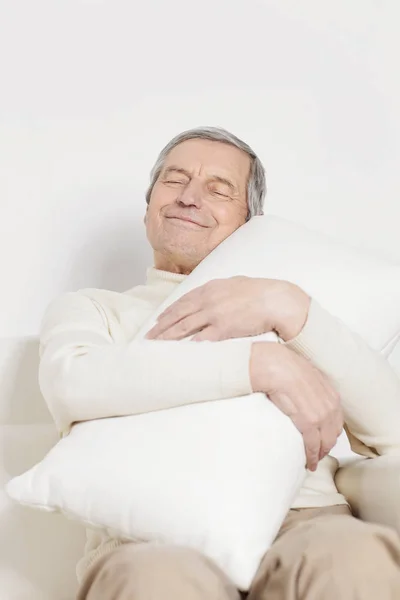 Anciano con una almohada confortable.aislado en blanco — Foto de Stock