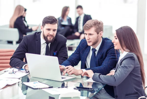 Equipo de negocios seguro de trabajar en el ordenador portátil con registros financieros — Foto de Stock