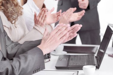 bir masanın arkasında oturan applauding iş takım