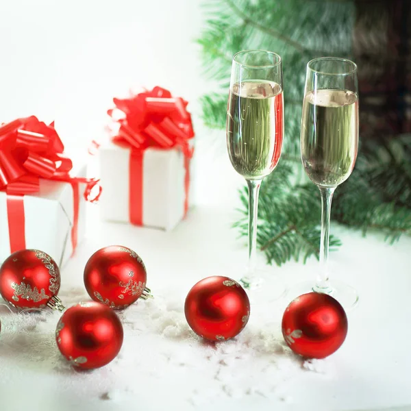 Two glasses with champagne and Christmas gifts at the Christmas — Stock Photo, Image