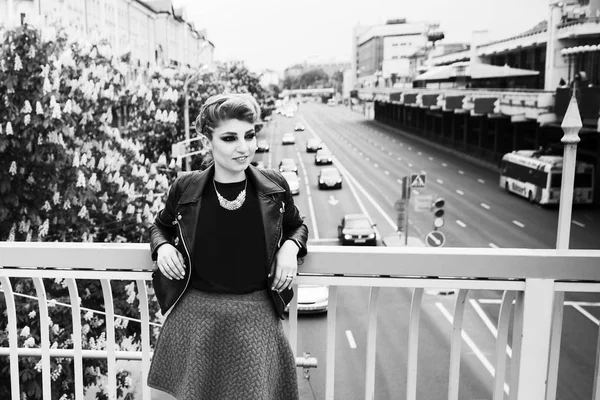 Foto en blanco y negro en estilo retro: hermosa mujer joven de pie en el puente en la gran ciudad —  Fotos de Stock