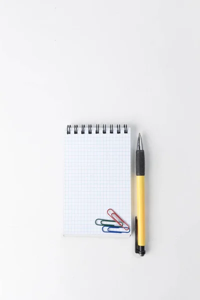 Notepad, pen and paper clip on white background .photo with copy space — Stock Photo, Image