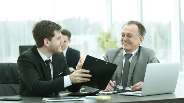 Jefe y empleado discutiendo el documento sentado en el escritorio en la oficina . — Foto de Stock