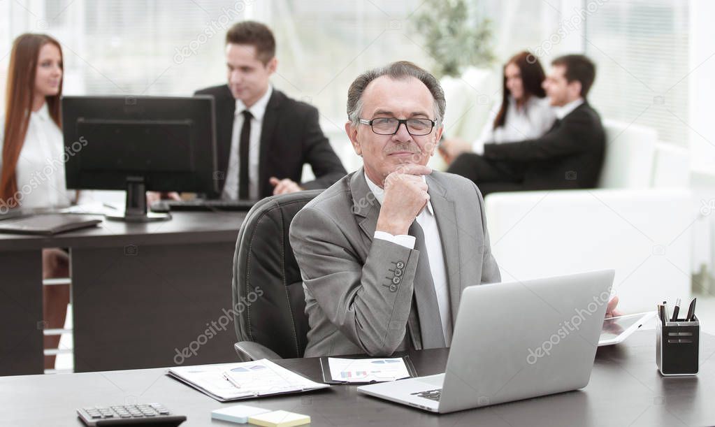portrait of adult businessman at the Desk in the office