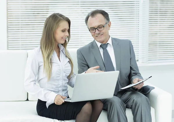 Senior Geschäftsmann und Assistent mit einem Laptop sitzt in der Lobby des Büros. — Stockfoto