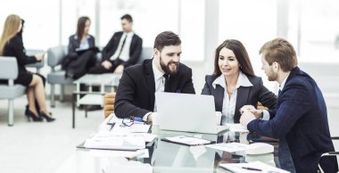 Başarılı iş ekibi dizüstü bilgisayarda çalışıyor ve güncel mali raporu hazırlıyor.