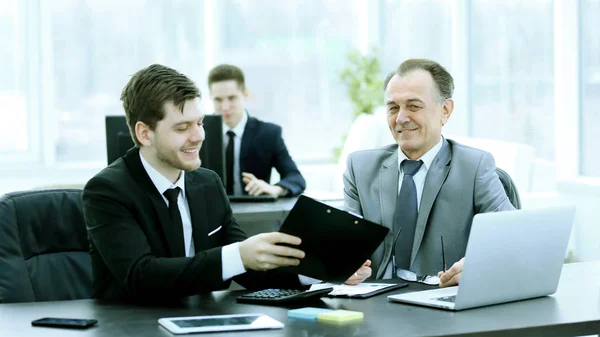 Volwassen zakenman financiële documenten met een jonge collega bespreken. — Stockfoto