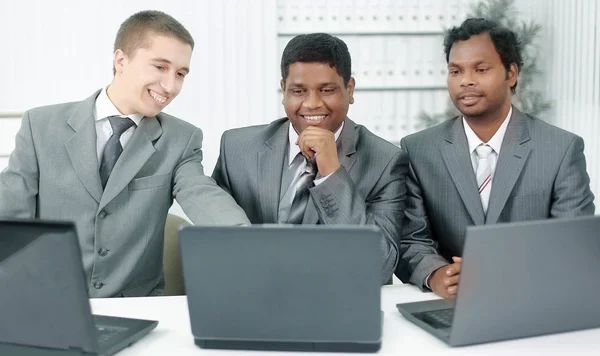 Parceiros de negócios discutindo informações com um laptop . — Fotografia de Stock