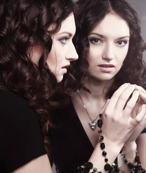 Glamorous beautiful woman looking at her reflection in the mirror. — Stock Photo, Image