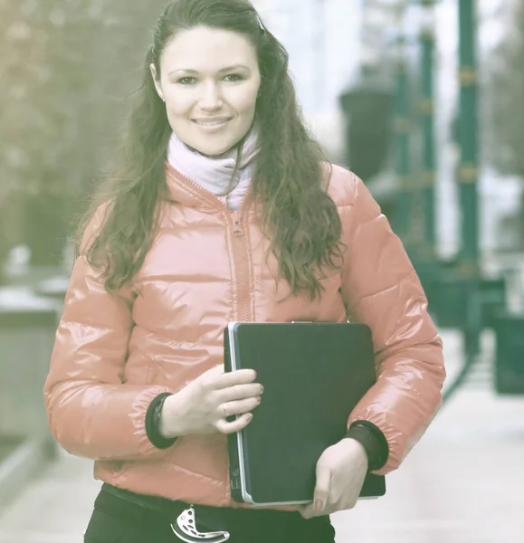 Smiling female student with laptop on the background of a winter city — Stock Photo, Image