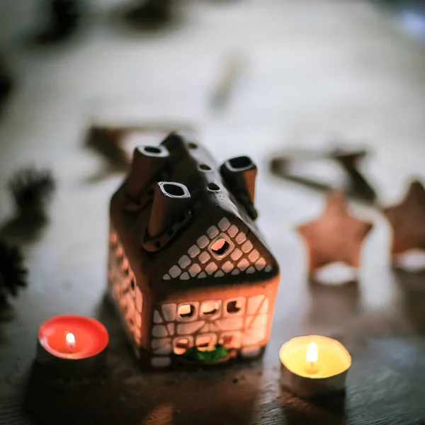 Gingerbread house candle on blurred background of the table. — Stock Photo, Image