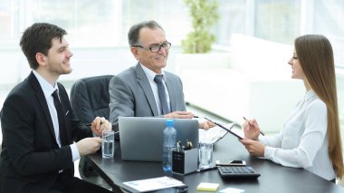 Müdürü ile yardımcıları masa başında iş sorunları tartışıyor