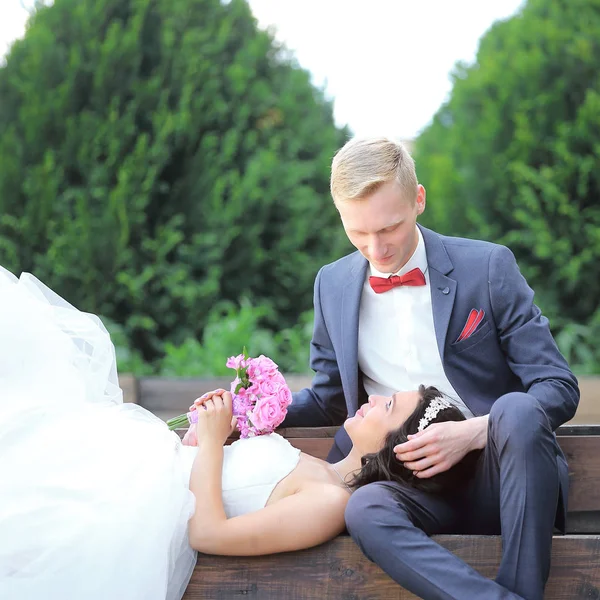 Счастливый жених держит невесту на коленях — стоковое фото